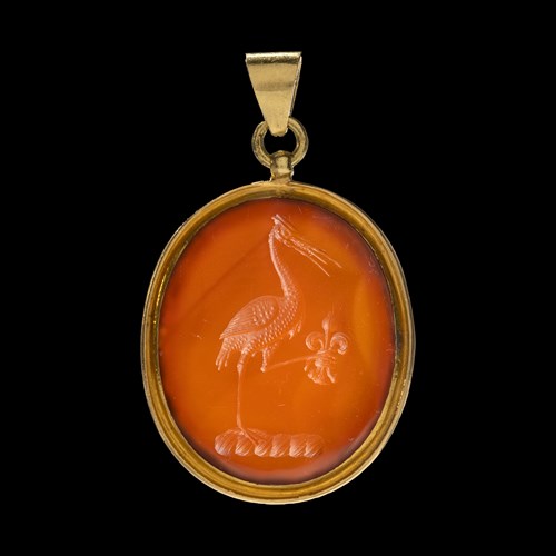 A gold pendant set with a Neoclassical carnelian intaglio. Allegorical scene with a crane.
